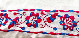 close up of embroidered flowers in fuchsia and blue