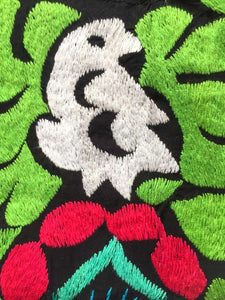 close up to detail of the white parrot hand embroidered  surrounded by bright pink and green flowers