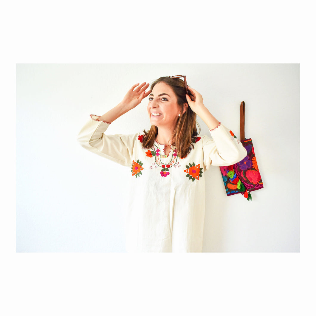 model wearing a mexican blouse with big orange embroidered flowers