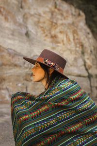 model wearing a green handmade wool rebozo and a brown hat boho vibes