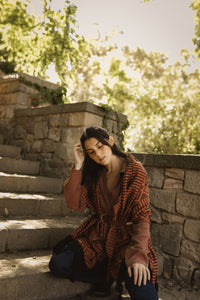 model wearing an orange rebozo with a belt