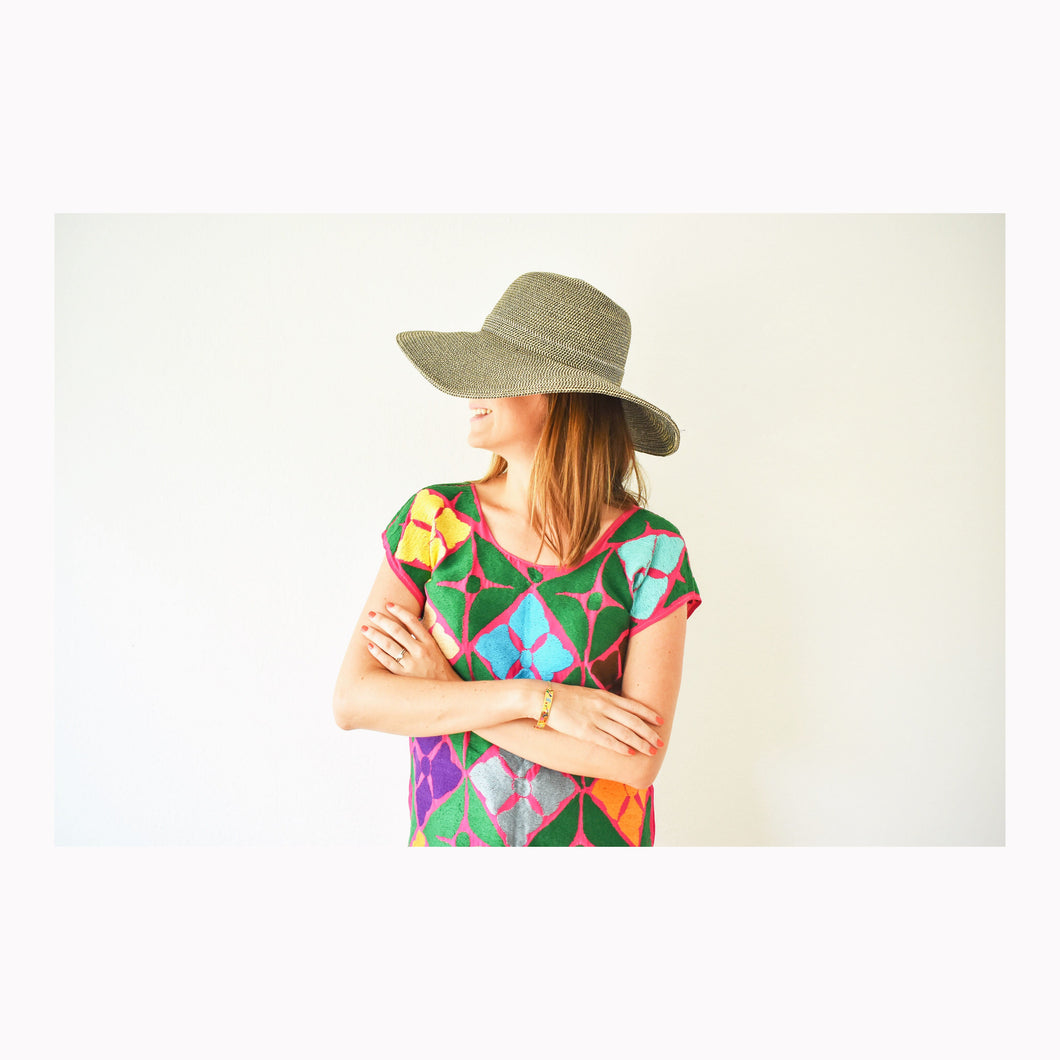 model wearing a fuchsia mexican blouse with wide brimmed hat