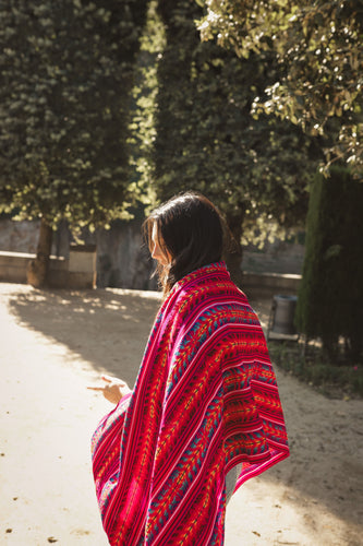 model wearing a bright pink rebozo covering her back